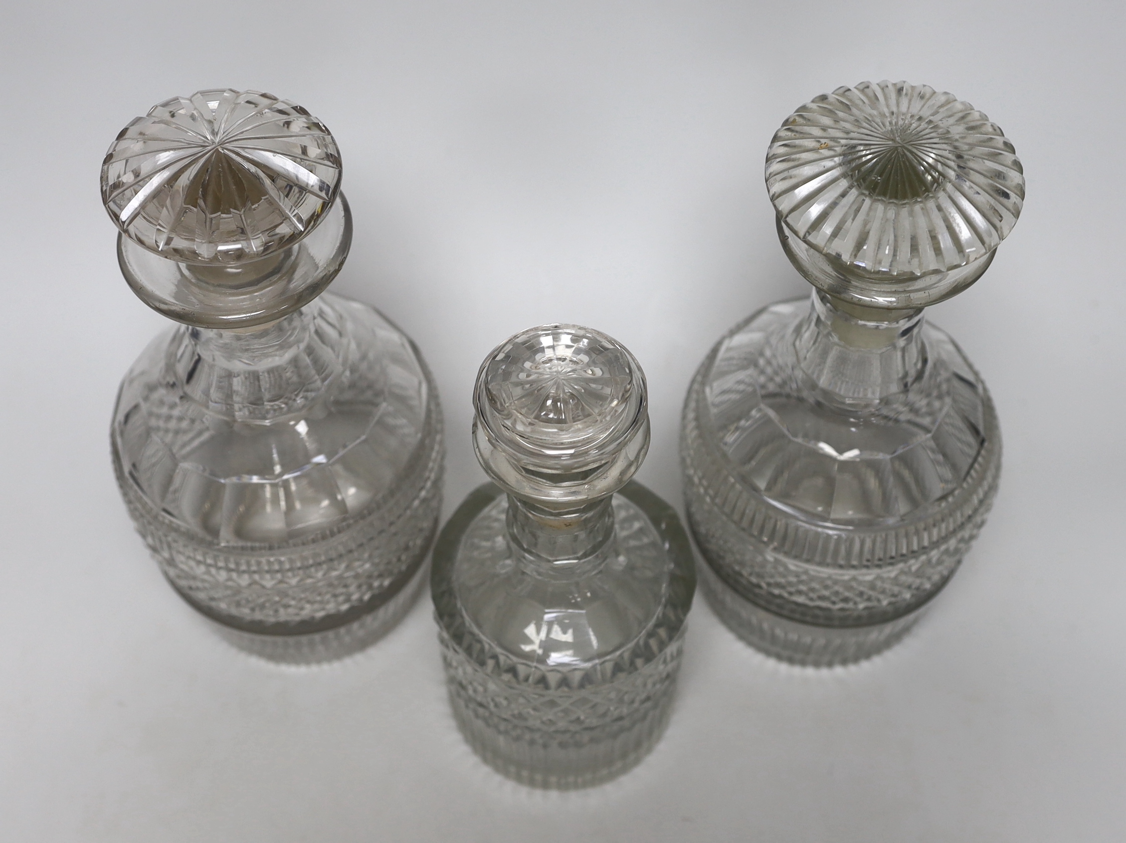 Three Georgian/Regency cut glass decanters, including a liqueur decanter, all with flattened stoppers, highest 25cm (3)